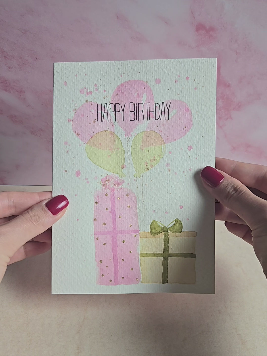 Produktvideo Geburstagskarte mit Motiv aus Luftballons und Geschenken, rosa goldene Geburtstagskarte, handgemalte Karte zum Geburstag